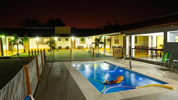 En swimmingpool med en redningsvagtstol og en person i en flydevest.
