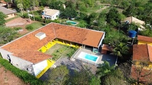 Una propiedad residencial con piscina, patio cubierto y jardín cercado.