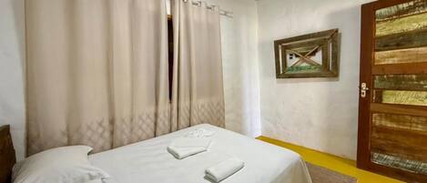 Una habitación con cama, puerta y aire acondicionado.