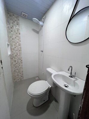 Un bany petit amb vàter, rentapel i plat de dutxa.