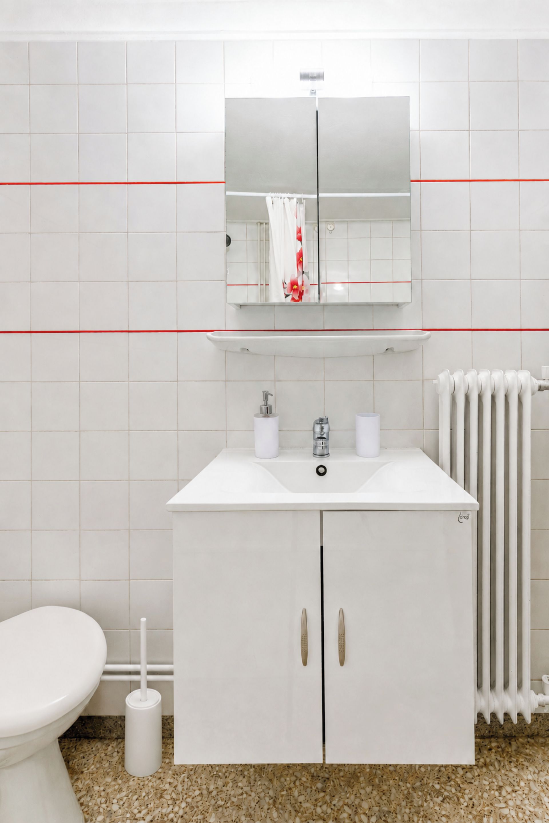 A bathroom with a white sink, mirror, and toilet.