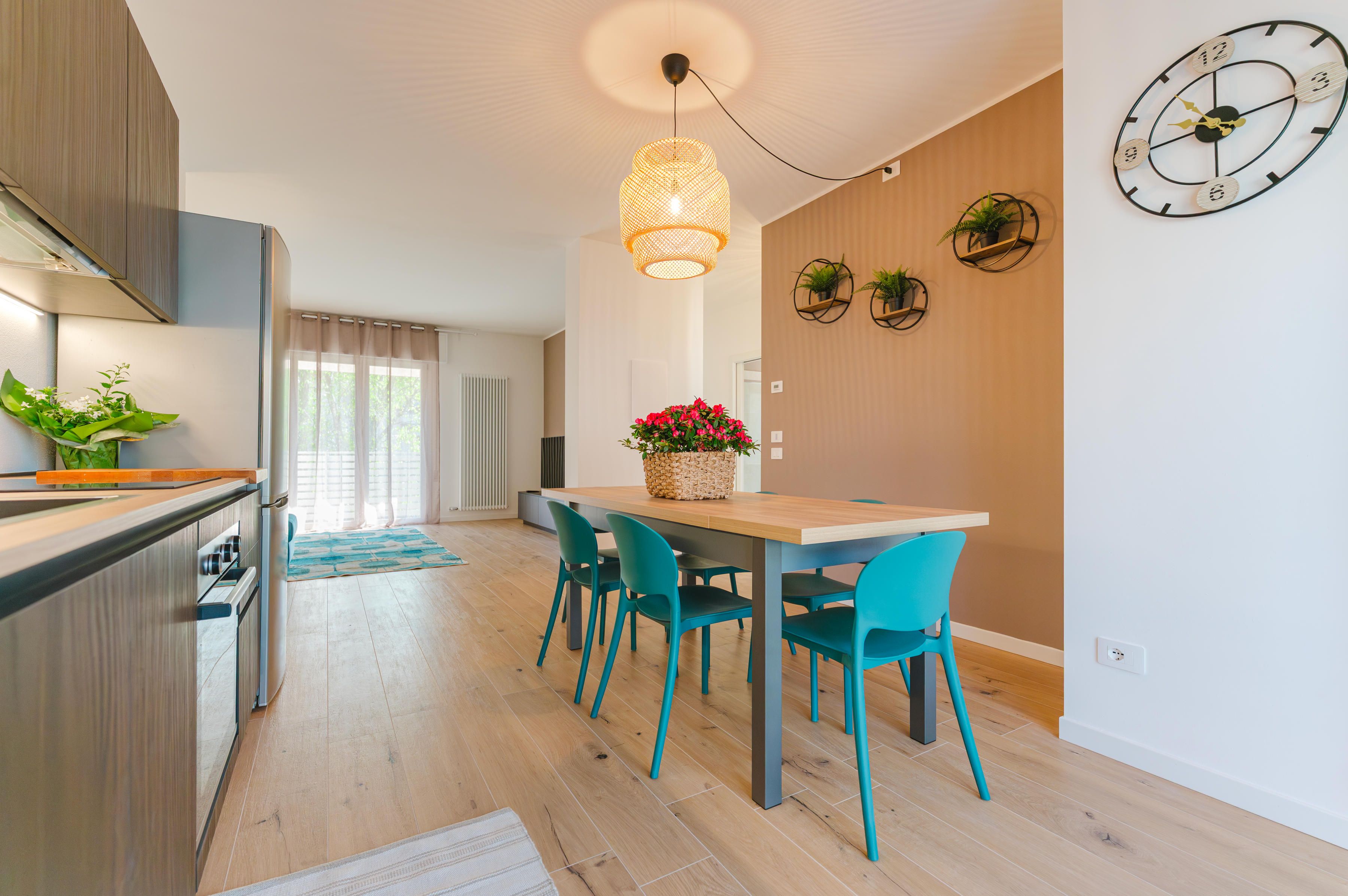 Een moderne keuken met een eethoek, houten vloeren en een klok aan de muur.