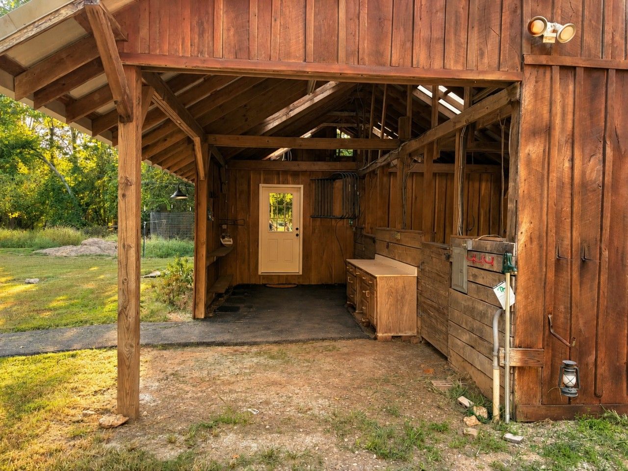 Une structure en bois dotée d’une entrée abritée, d’une porte et d’un banc à l’extérieur.