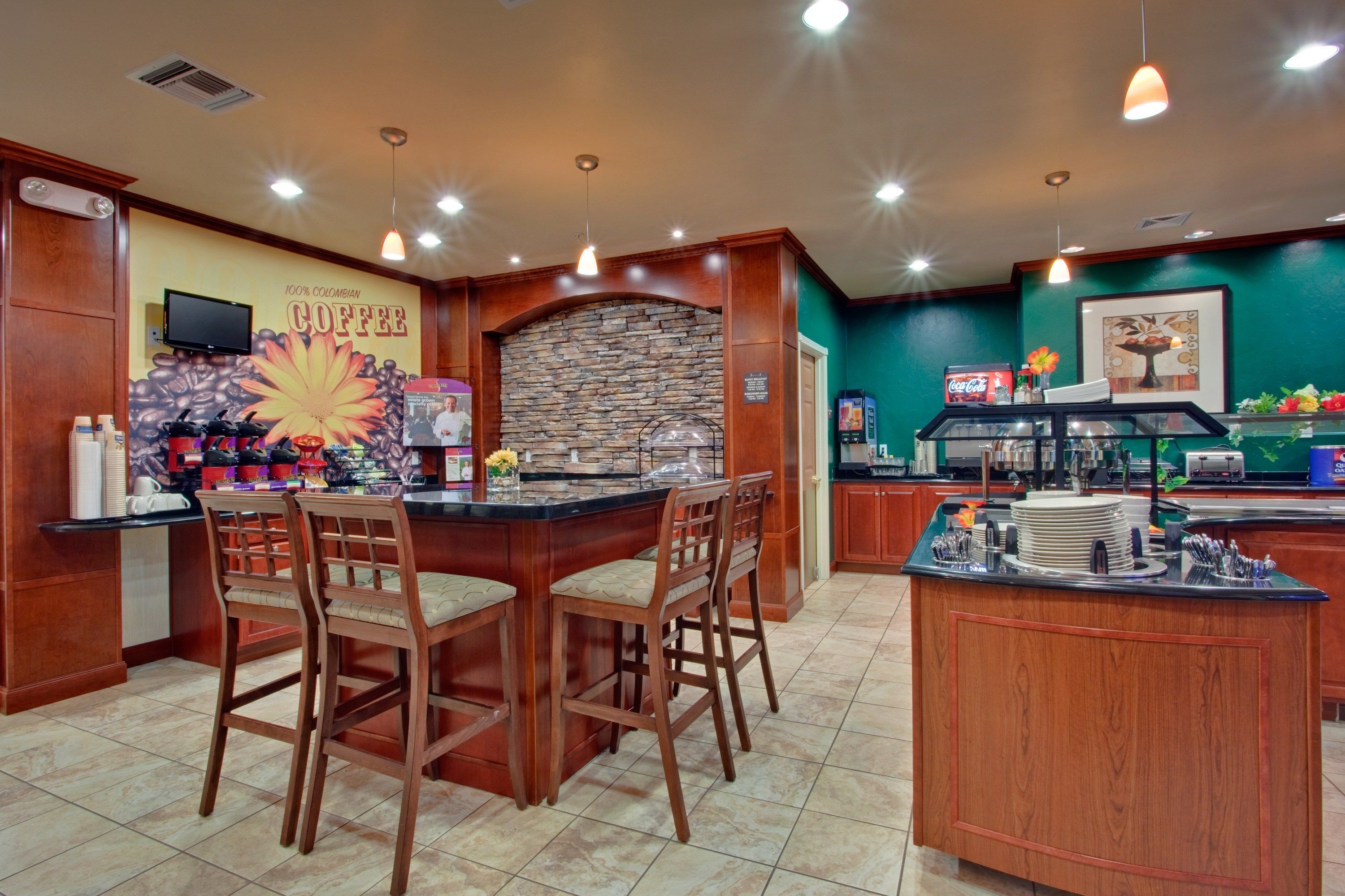 A coffee shop with a stone wall, wooden bar, and bar stools.