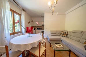 A living room with a round table, a sofa, and a chess table.