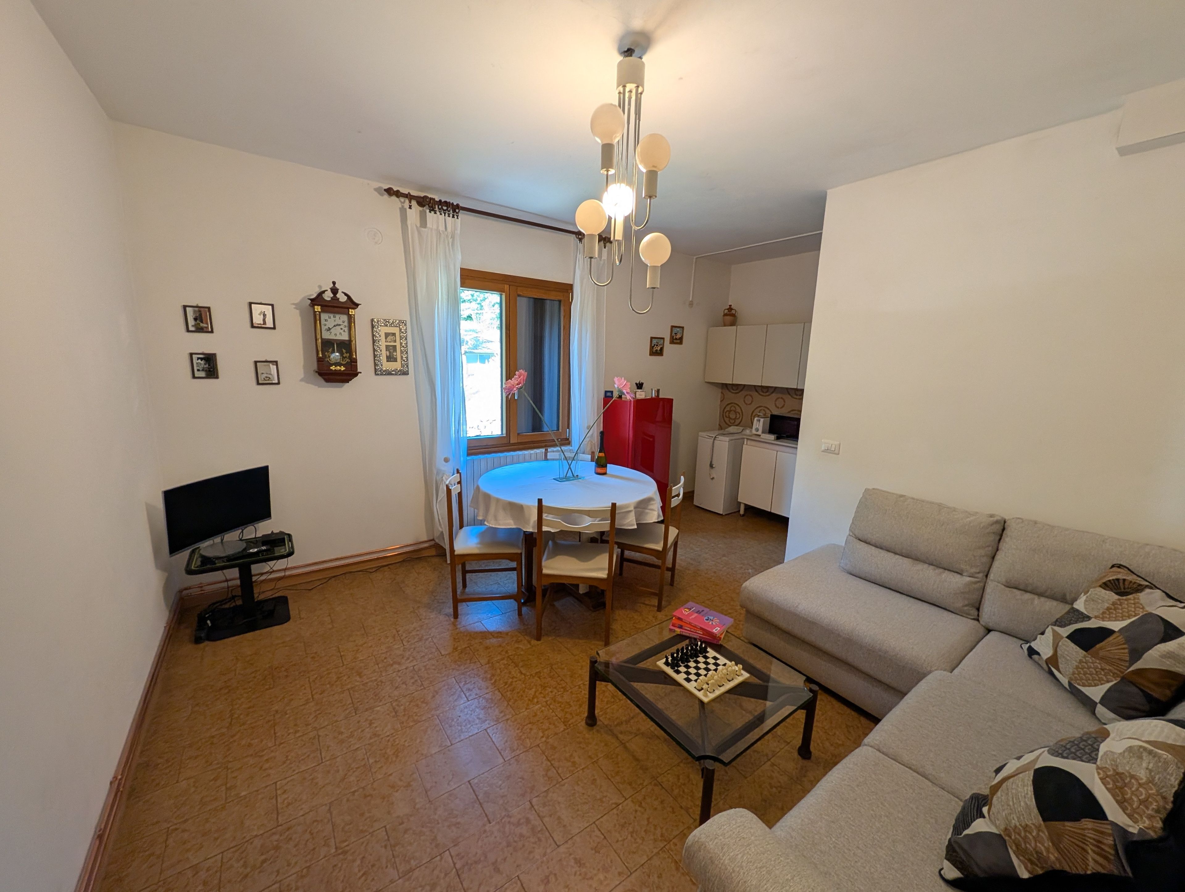 Ein Wohnzimmer mit einer Couch, einem Couchtisch und einem Essbereich mit Tisch und Stühlen.