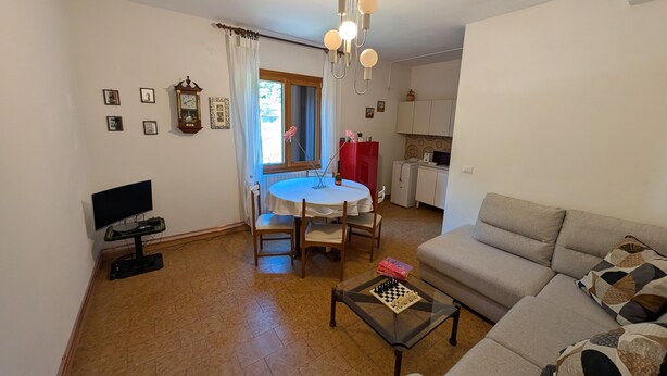 A living room with a sofa, a coffee table, and a dining area with a table and chairs. - Ca' Raul · Nestled among the Valtellina vineyards (Poggiridenti)