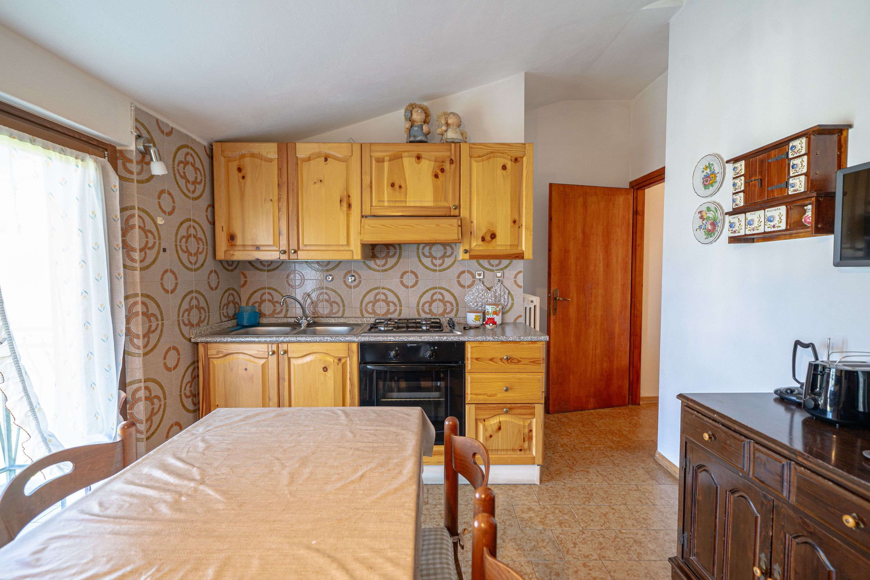 A compact kitchen with wooden cabinets, a gas stove, and a microwave.