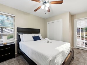 A bedroom with a bed, a nightstand, a ceiling fan, and a window with blinds. - Spacious 3 Bedroom East Dallas Retreat (Dallas)