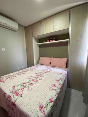 Ein Schlafzimmer mit einem Bett, einem eingebauten Kleiderschrank und einem Regal mit Dekoration.