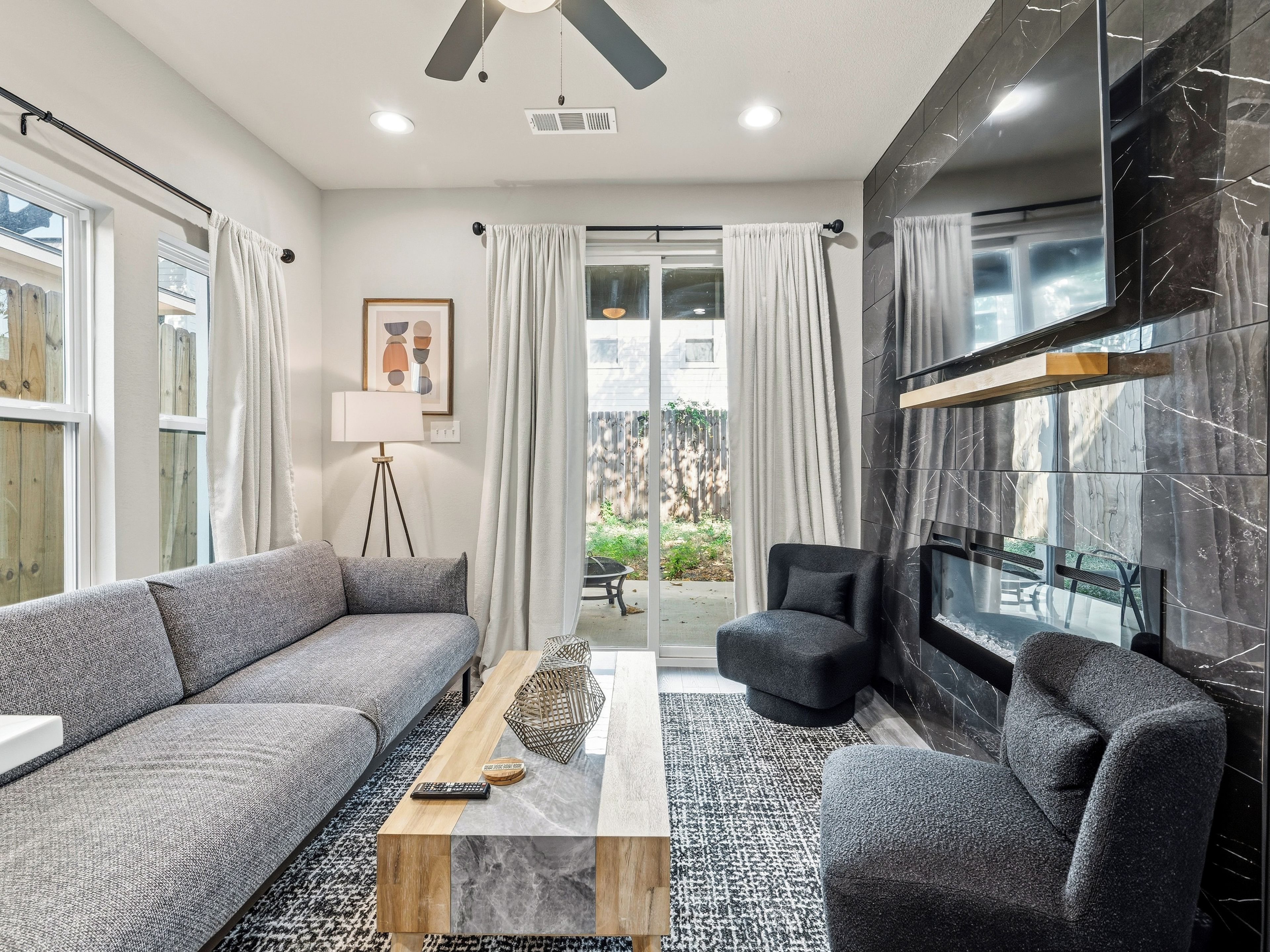 Un salon moderne avec un canapé, une table basse et une cheminée.