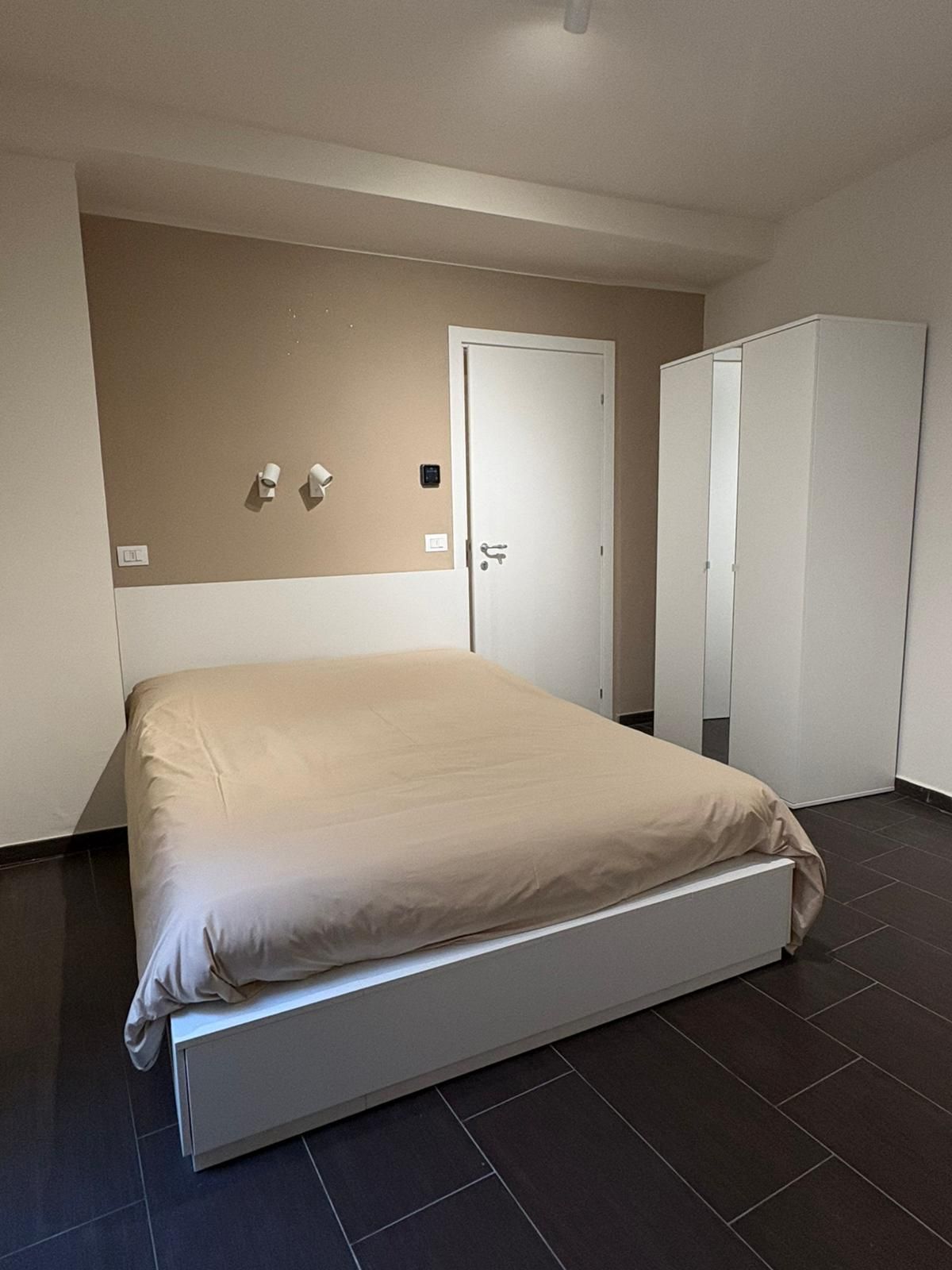 Une chambre à coucher avec un lit, une armoire et une porte.