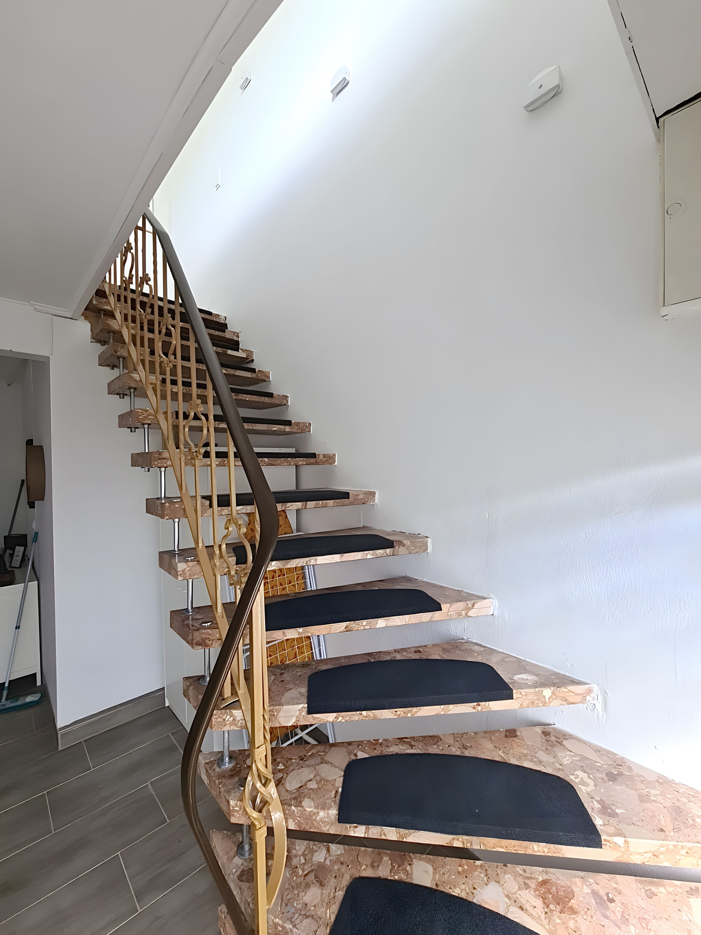Un escalier au design original, avec une finition en bois et une rampe en métal.