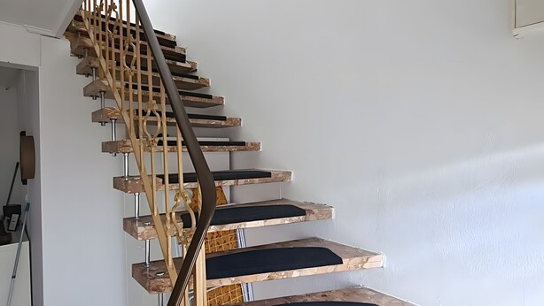 Un escalier au design original, avec une finition en bois et une rampe en métal.