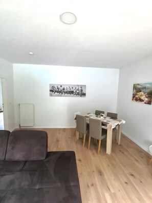Ein modernes Wohnzimmer mit einer Couch, einem Esstisch und Stühlen.