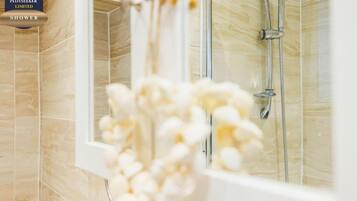 A shower with a glass door and a showerhead.