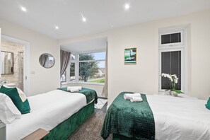 Ein Hotelzimmer mit zwei Betten, einem Badezimmer und einem Fenster mit Blick.