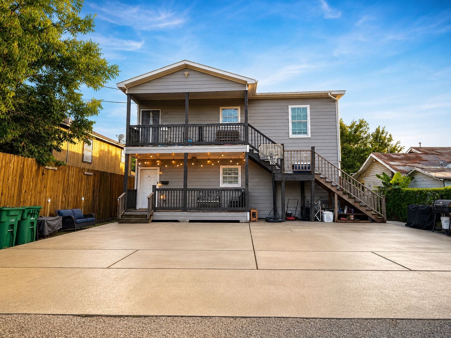 A two-story house with a covered front porch, a visible staircase, and a driveway.