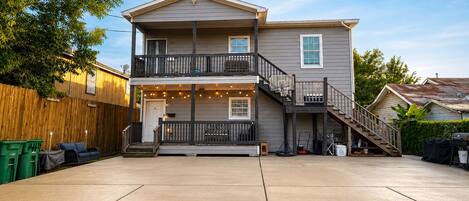 A two-story house with a covered front porch, a visible staircase, and a driveway.