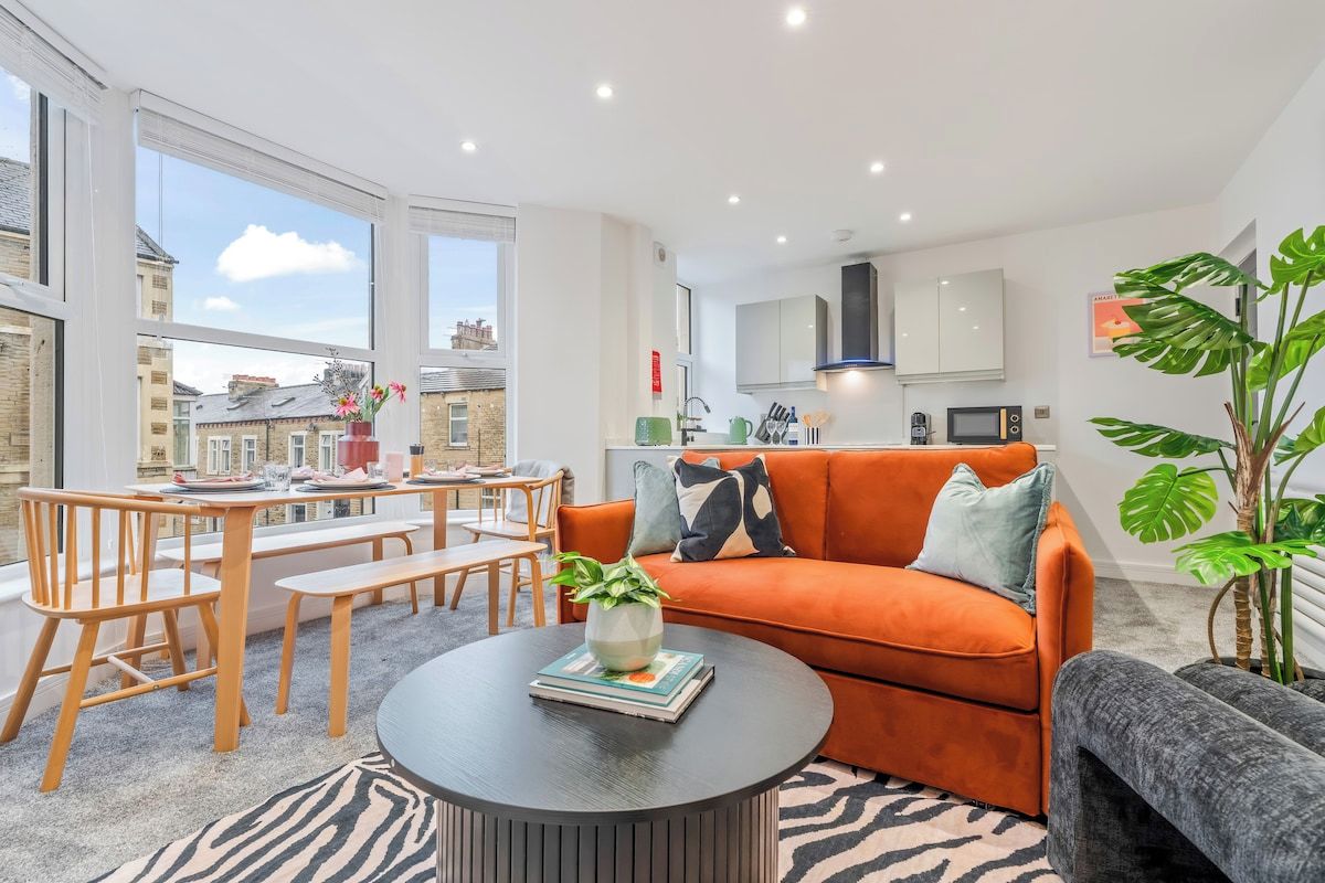 A modern living room with a sofa, coffee table, and dining area.