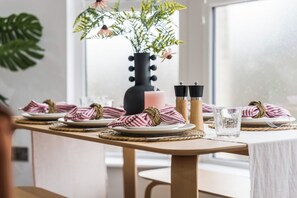 A dining table set with plates, napkins, and a candle. - Coastal retreat near Morecambe Bay and promenade (Heysham)