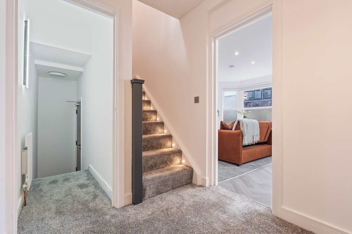 A staircase with carpeted steps leading to a second-floor area.