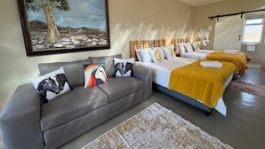 Un dormitorio con una cama grande, un sofá y un cuadro en la pared.