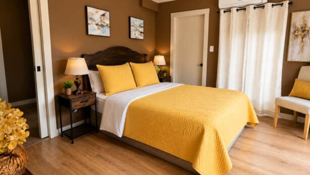 A hotel room with a bed, bedside tables, a chair, and artwork on the walls. - Beaver Creek Chalet | 1 Bedroom | Sleeps 6 | Pet Friendly (Alberni-Clayoquot)