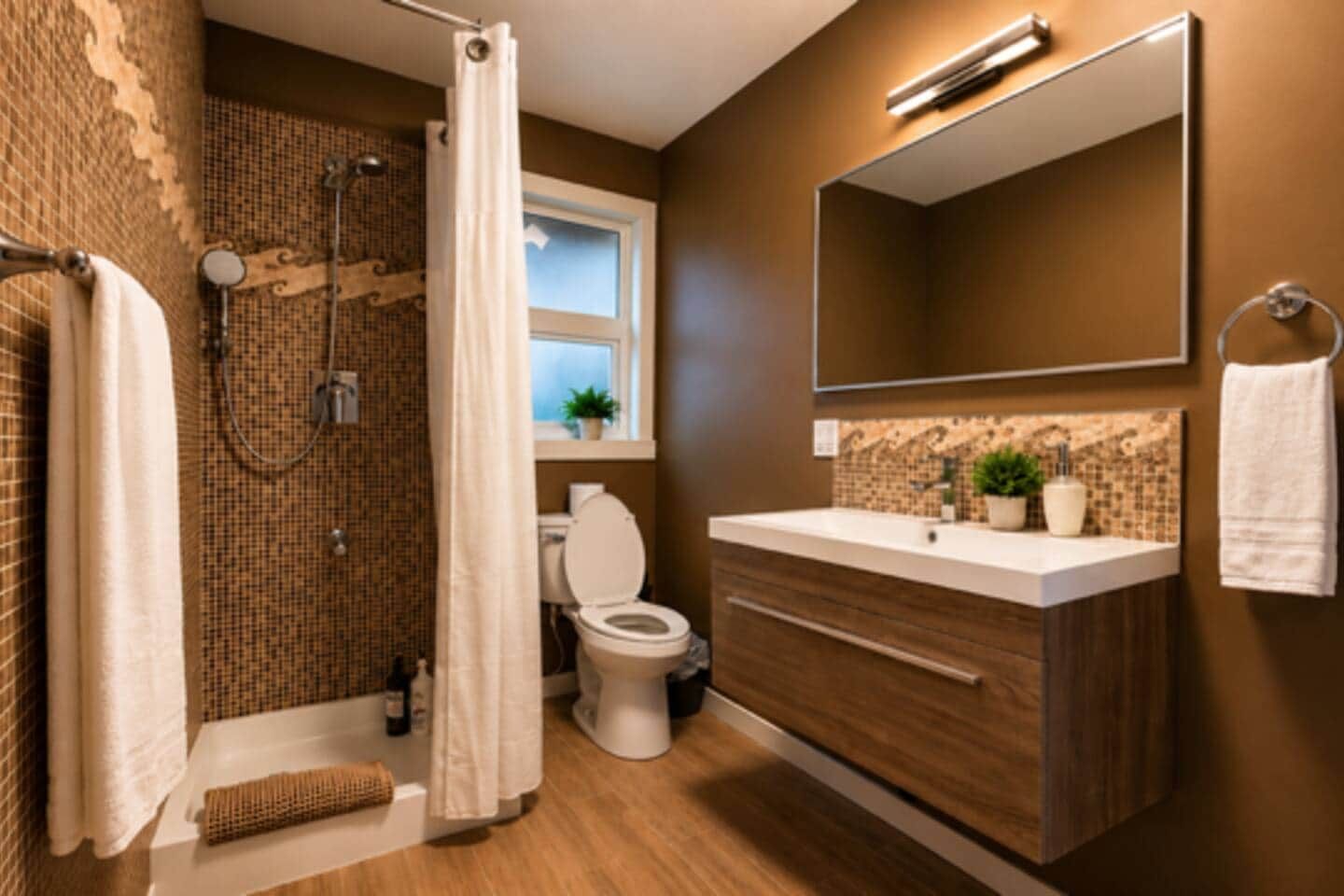 Une salle de bain moderne équipée d’une douche, de toilettes et d’un meuble-lavabo.