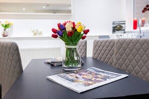 Ein Tisch mit einer Tulpenvase, einer Zeitschrift und einer weißen Arbeitsplatte im Hintergrund.