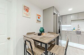 Una cocina moderna con una mesa de comedor, sillas y armarios de cocina.