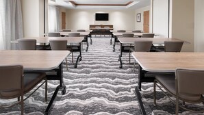A conference room with a long table, multiple chairs, a carpeted floor, and a flat-screen TV mounted on the wall. - Accessible King Studio w/ Roll Shower & Breakfast (Harrisburg)