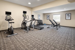 A gym with treadmills, an elliptical, and a bench press area.