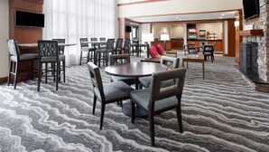 A hotel lobby with a large seating area, a bar, and a fireplace. - Accessible King Studio w/ Roll Shower & Breakfast (Harrisburg)