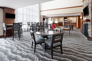 En hotellobby med en stor sittgrupp, en bar och en öppen spis.