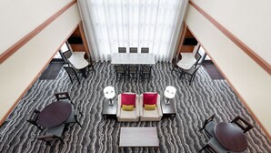 A hotel lobby with a central seating area, a staircase, and a view of the upper floor. - Accessible 2BR Suite w/ Kitchen | Free Breakfast! (Harrisburg)