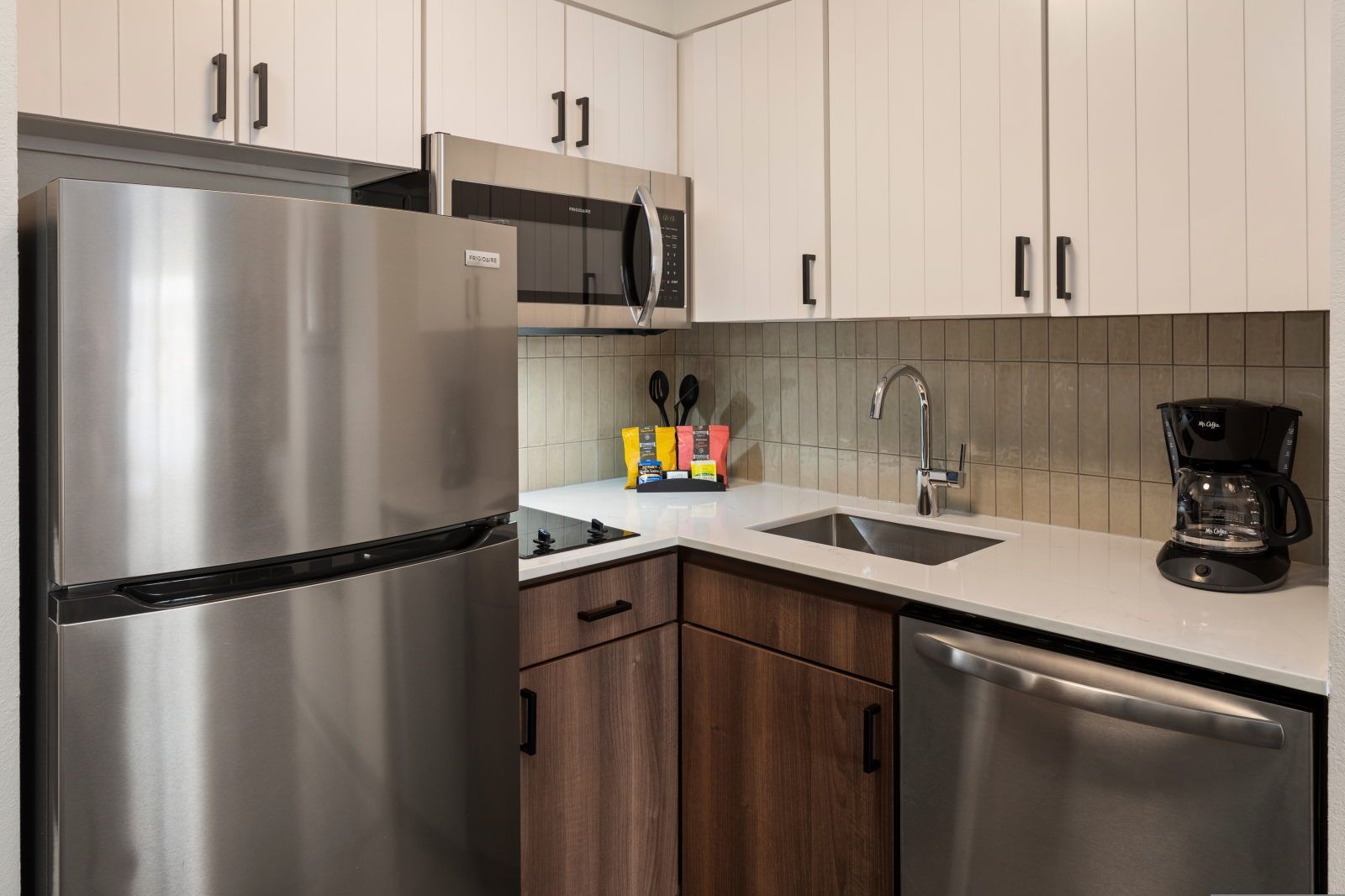 A modern kitchen with stainless steel appliances, a microwave, and a coffee maker.