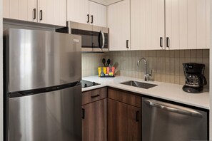 A modern kitchen with stainless steel appliances, a microwave, and a coffee maker.