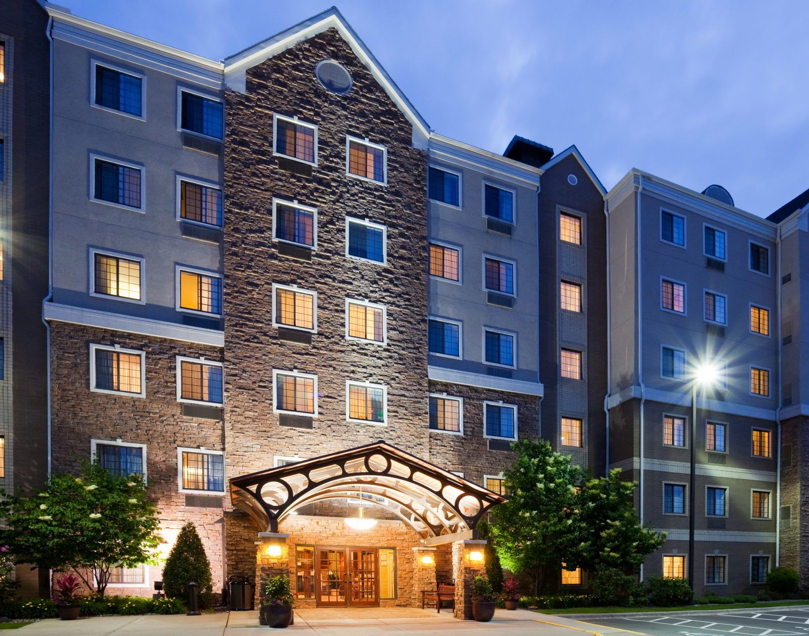 A multi-story hotel with a stone facade, multiple windows, and a covered entrance.