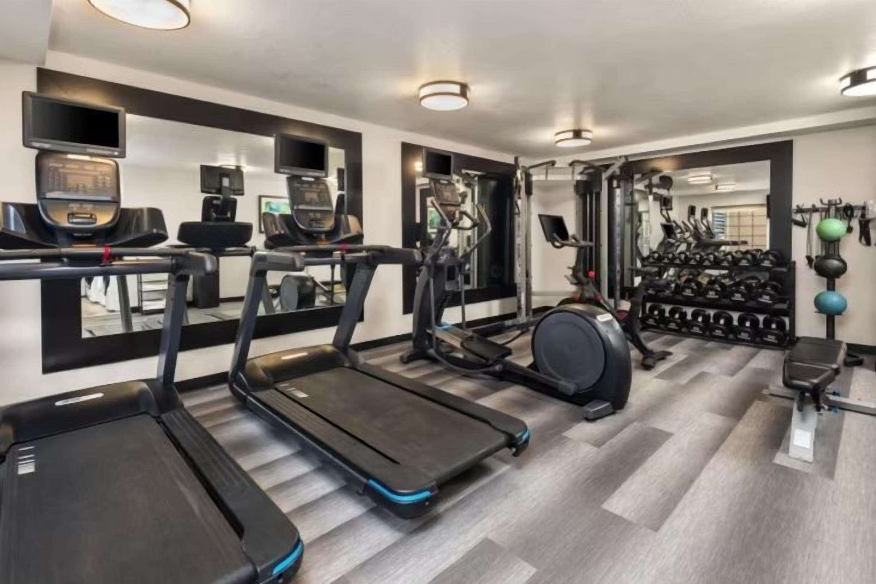 A gym with treadmills, a stationary bike, and a weight rack.