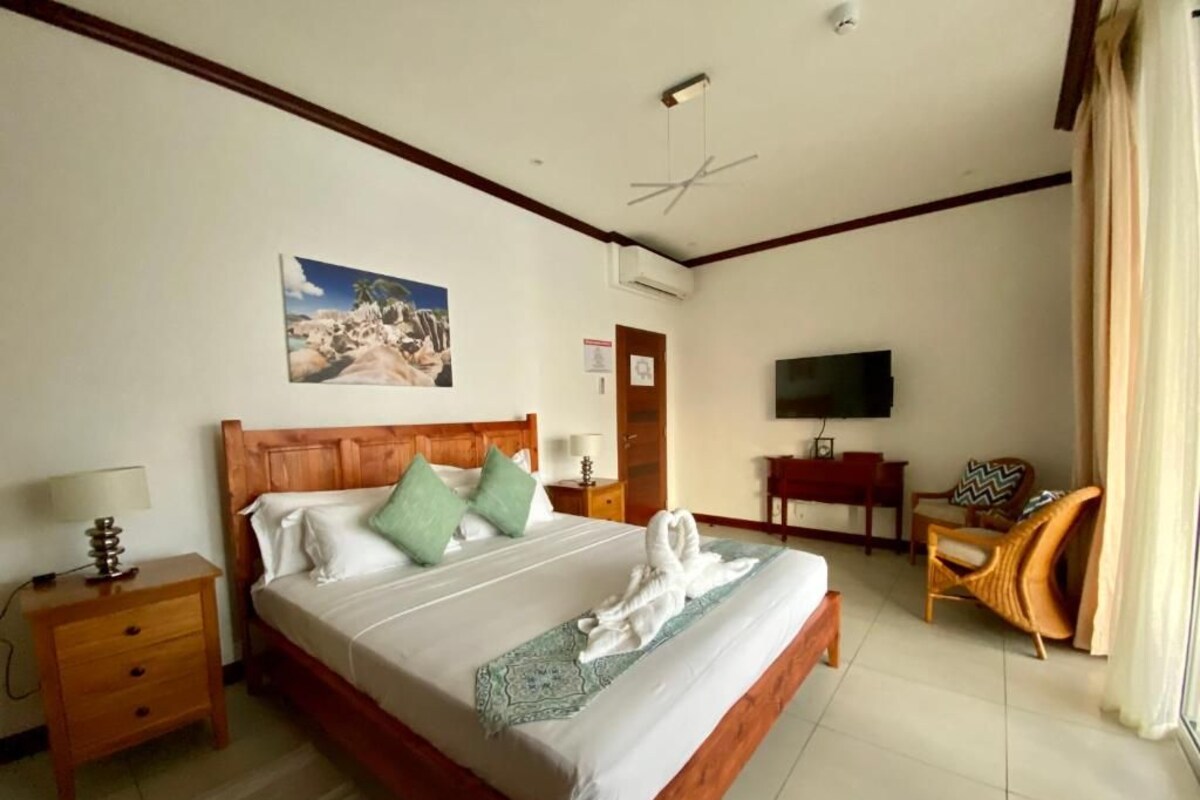 Une chambre d’hôtel avec un lit, une télévision, un bureau et une chaise.