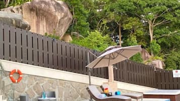 A swimming pool with lounge chairs and a shaded area.