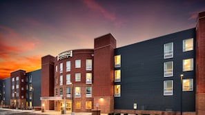 A Staybridge Suites hotel with a brick facade, multiple windows, and a sign indicating accessibility.