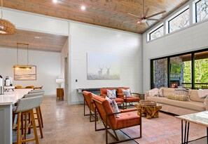A spacious living area with a fireplace, seating, and a view of the outdoors. - 2 Nearby Cabins | Private Heated Pool | Sleeps 34 (Broken Bow)