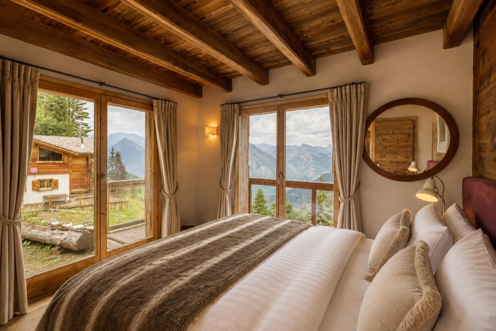 Un dormitorio con una cama grande, vigas de madera, vistas a montañas y una cabaña de madera en el exterior.