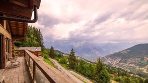 Un terrazzo in legno con vista su un paesaggio montuoso.
