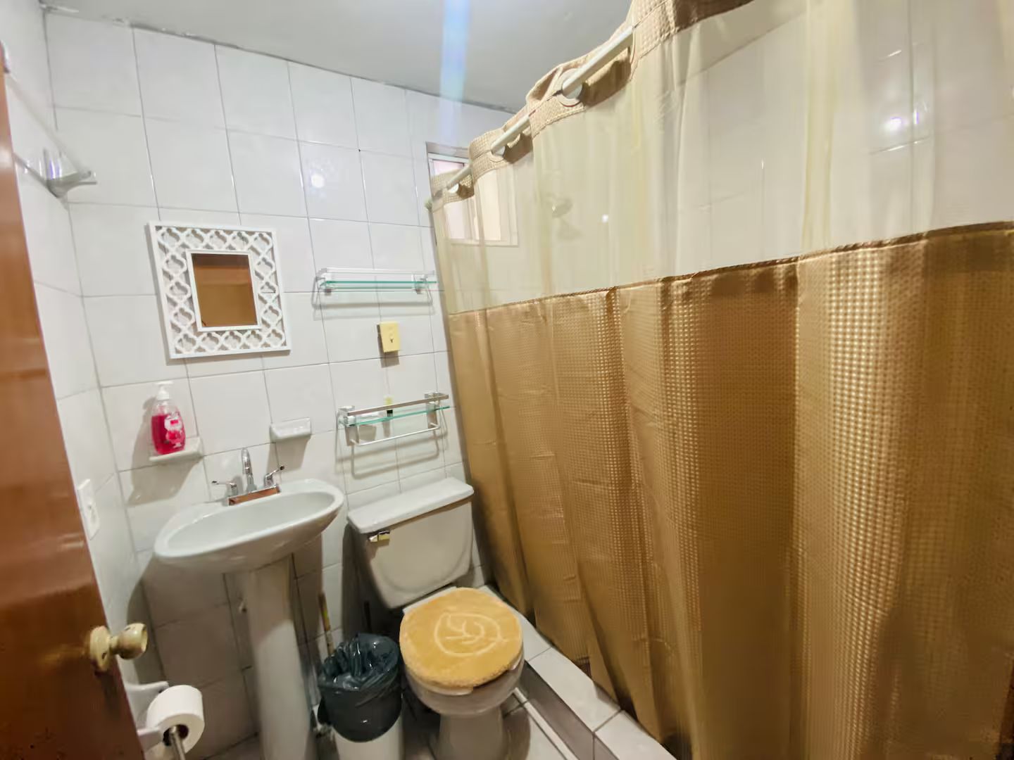 Un baño con inodoro, lavabo y cortina de ducha.