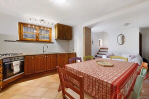 A compact kitchen with a gas stove, oven, and wooden cabinets. - Holiday Home 'Vacanza Tra Gli Olivi - Camaiore' with Wi-Fi and Air Conditioning (Camaiore)