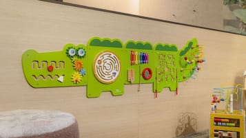 A wall with educational toys and a toy box.