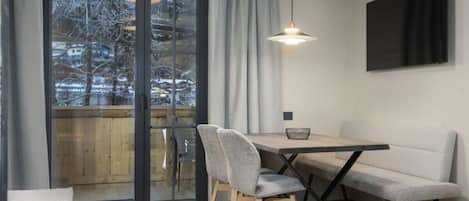A modern dining area with a table, chairs, and a bench.